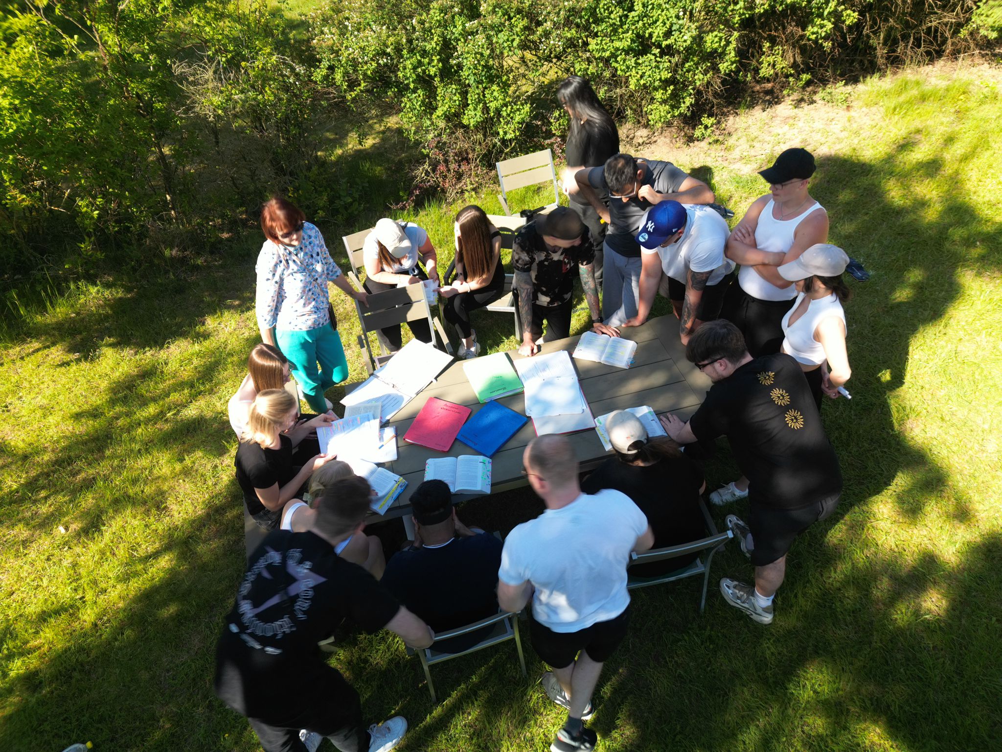 Schüler und eine Lehrerin in der Natur an einem Tisch