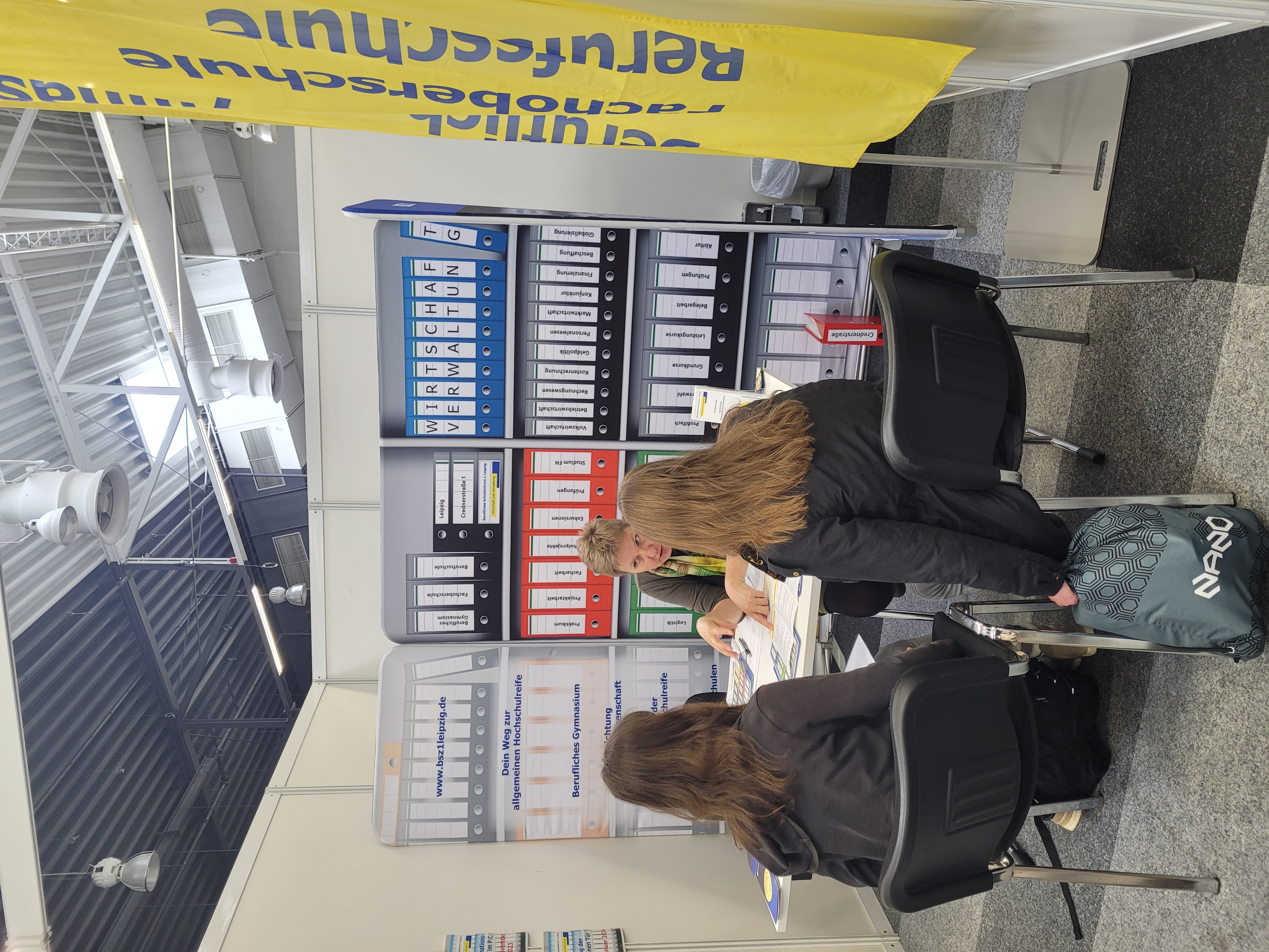 2 Schülerinnen lassen sich an Messestand beraten